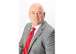 Image of Brent Finley in a grey suit with red tie on a white background